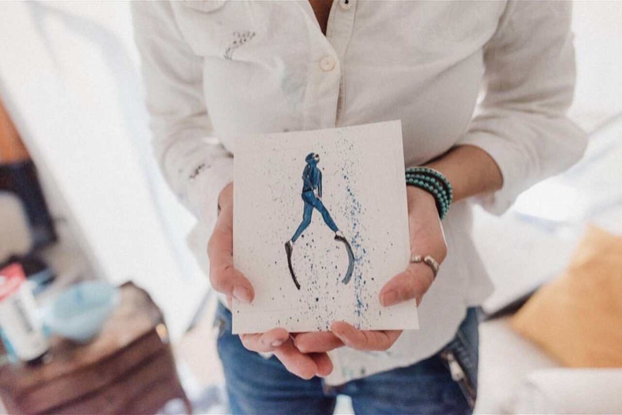 Jennifer Nicholson holding one of her small paintings
